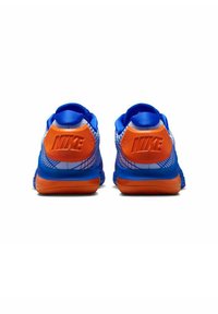 Nike-Sneaker in Blau und Orange, mit einem strukturierten Obermaterial, gepolstertem Kragen und Gummisohle. "Nike"-Logo in den Absatz eingeprägt.