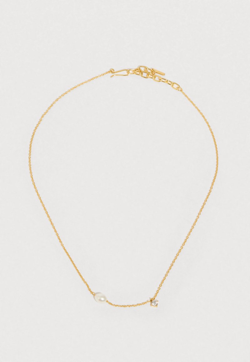 Colar de corrente dourada com uma pérola lisa e um pequeno detalhe de cristal, textura delicada e fecho de lagosta.