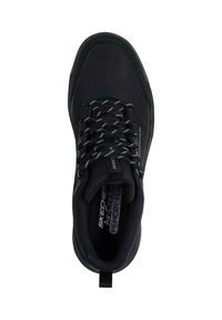 Zapatilla deportiva negra con parte superior de tela texturizada, cordones blancos que contrastan y suela acolchada con una lengüeta para tirar en el talón.