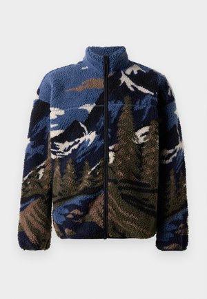 Giacca zip-up in pile di colore blu, verde e marrone con motivi di montagne e foreste. Presenta un colletto alto e un tessuto morbido e testurizzato.