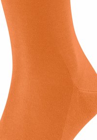 Calzino in cotone arancione con lavorazione a maglia liscia e texture. Presenta un colore uniforme senza motivi o dettagli aggiuntivi.