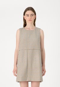 Vestido sem mangas numa padronagem de pé de galinha em amarelo, azul e branco. Corte reto, até ao joelho, com decote arredondado e tecido texturizado.