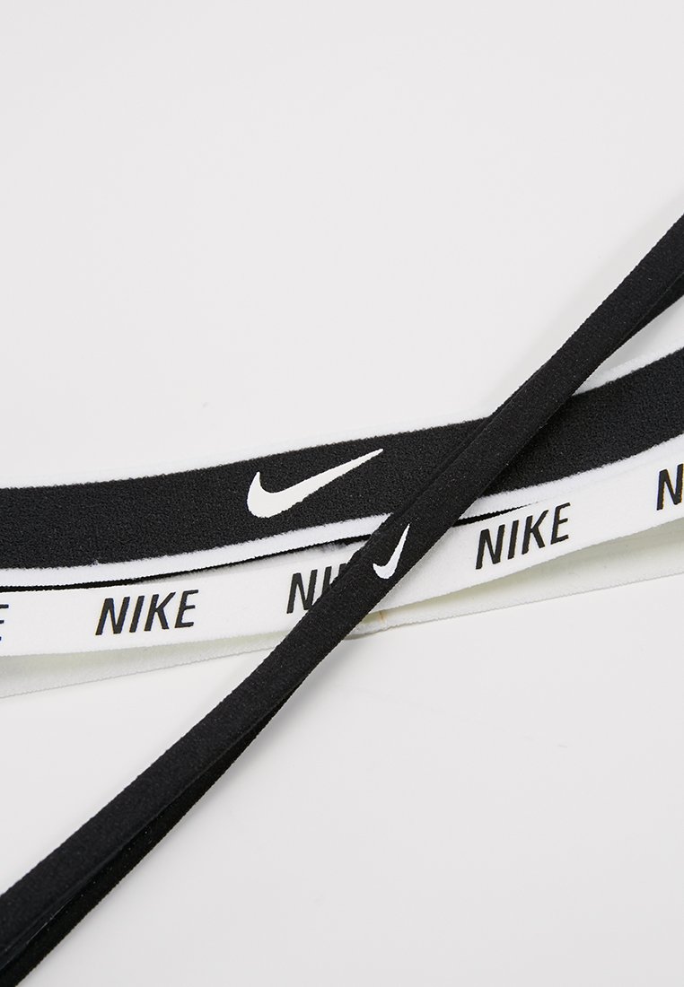 Gomas elásticas en blanco y negro con el texto 'NIKE', una goma es negra con un logo blanco, la otra es blanca con letras negras.