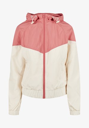 Színblokkolt dzseki, amely pink felső részből és krém alsó feléből áll, kapucnival, elöl cipzárral, valamint elasztikus mandzsettákkal és alsó szegéllyel.