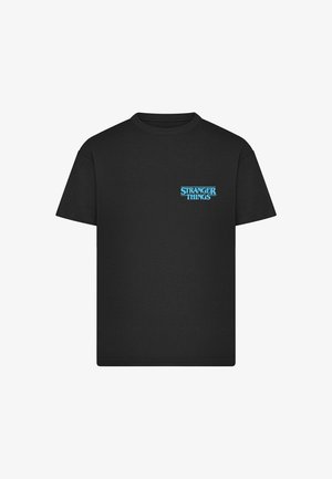 T-shirt nera a maniche corte con piccolo logo blu di "Stranger Things" sul lato sinistro del petto su sfondo bianco.