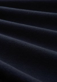 Țesătură de culoare bleu marin cu o textură fină și nervuri, având pliuri netede și ondulate. Materialul pare moale și ușor.