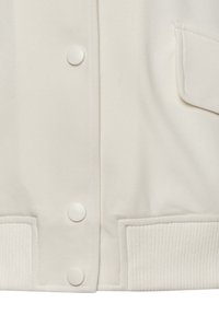 Bílá varsity bunda s hladkým povrchem, patentkami, vroubkovanými manžetami a boční kapsou s čistým prošíváním.