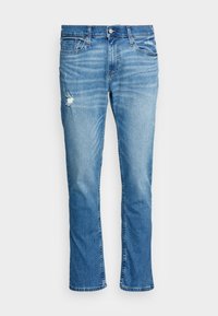 Ljust blå denimjeans med rak passform, som har ett slitaget detalj vid knäet och subtila slitningar fram.