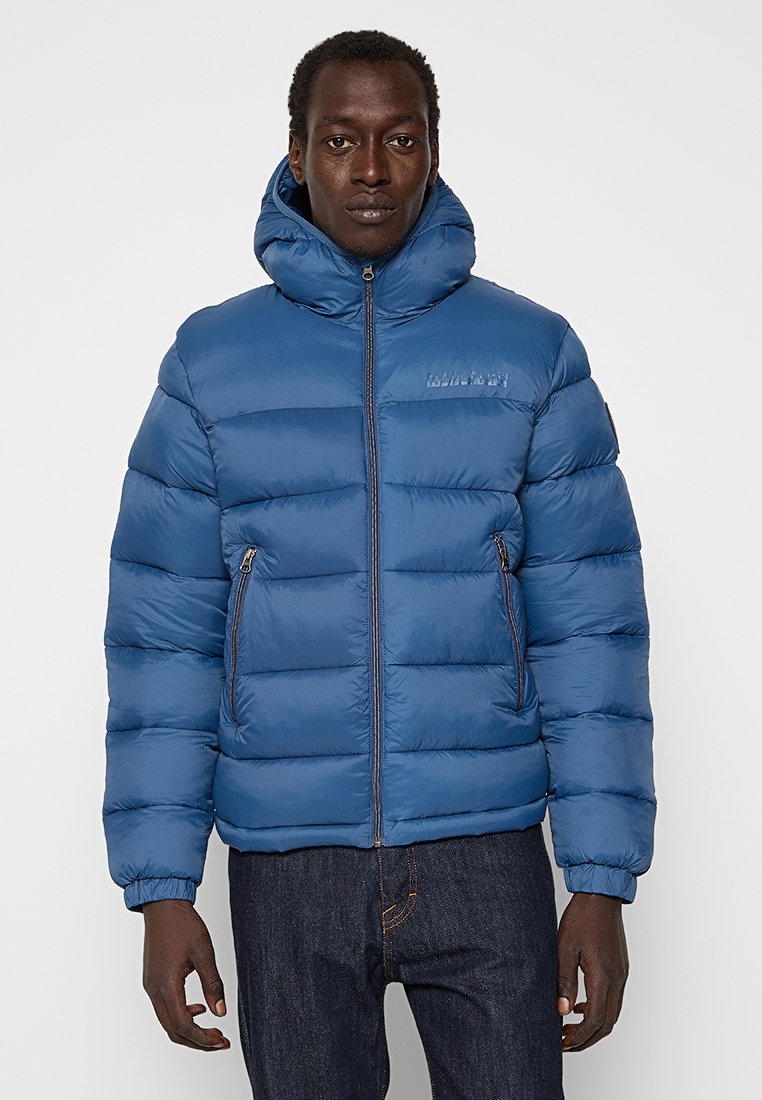 Chaqueta acolchada azul con cuello alto, diseño de acolchado horizontal, bolsillos frontales con cremallera y puños elásticos. Textura suave y brillante.