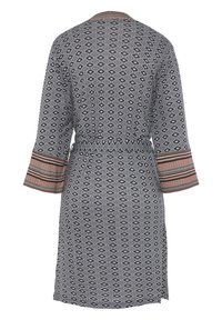 Musterierter schwarz-weißer Kimono mit Rautenmotiven, drei Viertel langen Glockenärmel, einem taillierten Gürtel und gestreiften Akzenten an den Manschetten.