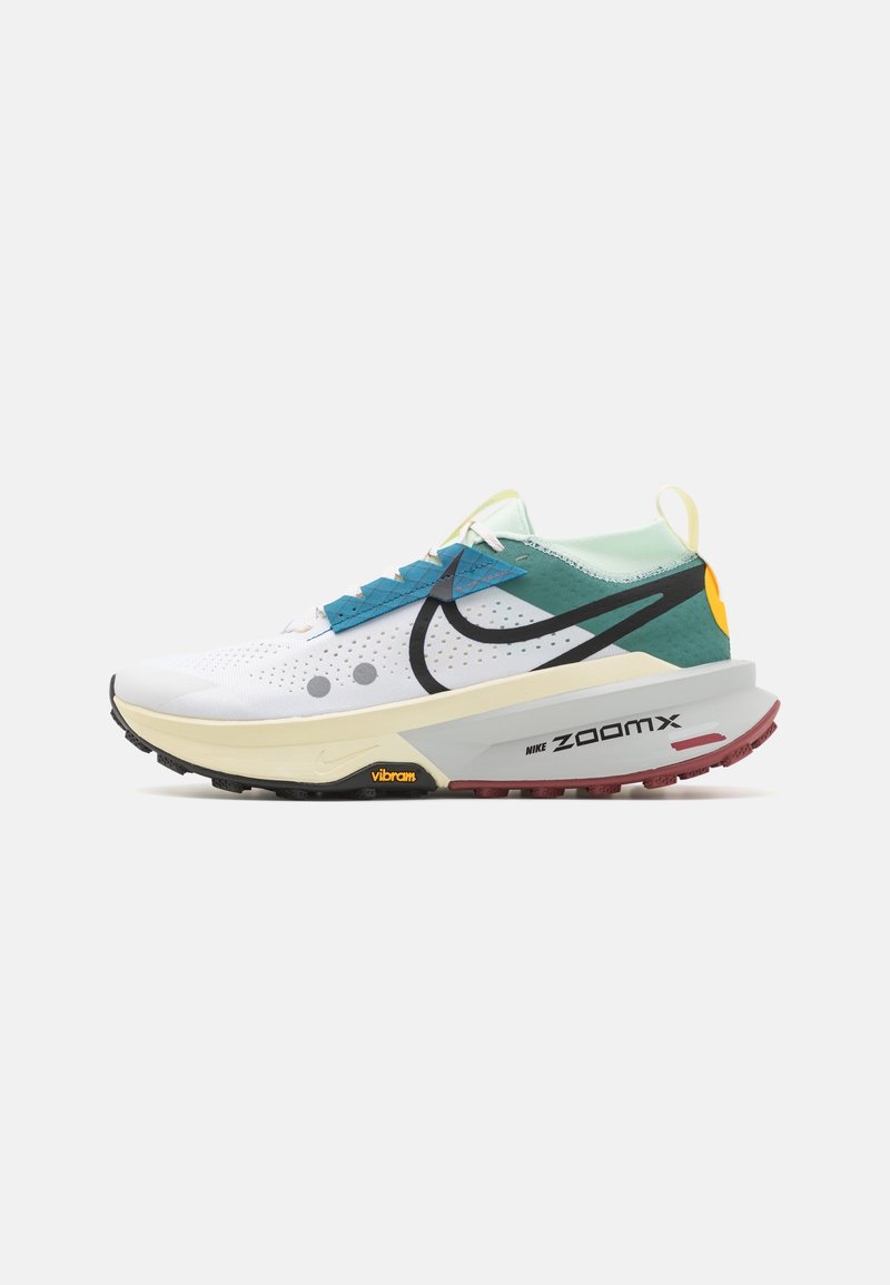 Chaussure de course moderne blanche, bleu sarcelle et jaune avec un logo Nike noir, semelle Vibram et amorti ZoomX sur fond uni.