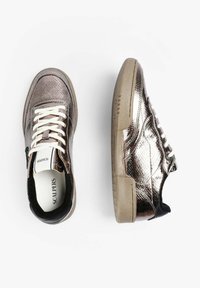 Zapatillas de deporte de bronce metálico con cuero texturizado, cordones blancos y suela de goma beige. Detalles negros en el talón y la lengüeta.