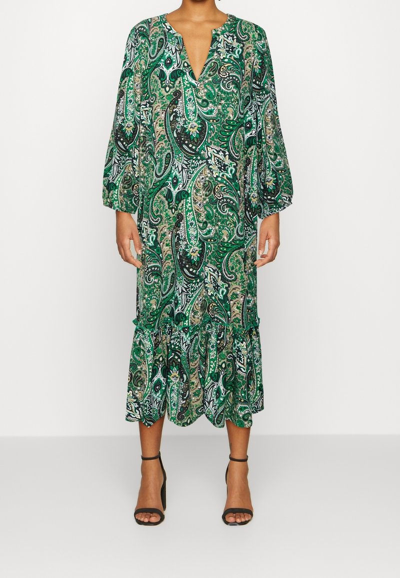 Zelené šaty s paisley potiskem, s nabíranými rukávy, výstřihem do V a volánkovým lemem. Vyrobené z lehkého materiálu s propracovanými detaily vzoru.