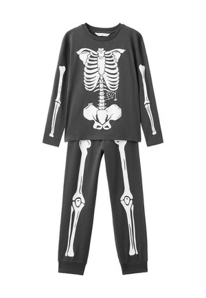 Ensemble de pyjama noir à manches longues présentant une impression de squelette blanc à l'avant du haut et des motifs de jambes sur le pantalon. Tissu doux, coupe casual.