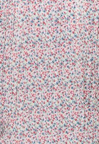 Blumendruckstoff in Pastellfarben, mit kleinen rosa und blauen Blumen auf einem weißen Hintergrund und vertikalen Falten für Textur.