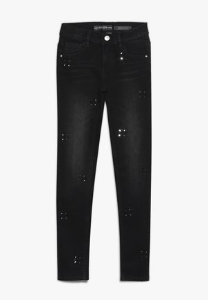 Schwarze Skinny-Jeans mit Knopfverschluss, Vorder- und Gesäßtaschen sowie kleinen dekorativen ausgeschnittenen Blumenmustern, die über die Beine verteilt sind.
