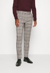 Karierte Hose mit einem beigen, braunen und schwarzen Muster, taillierte Passform, mit seitlichen Taschen und einem Gürtelschlaufenbund.