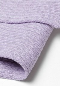 Tissu lilas à côtes avec une texture douce, présentant un bord replié et des fils légèrement flous, créant une apparence confortable.