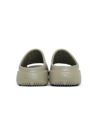 Zapatos de color verde oliva tipo slip-on, hechos de un material similar al caucho, con una superficie texturizada y un talón reforzado con un patrón de surcos.