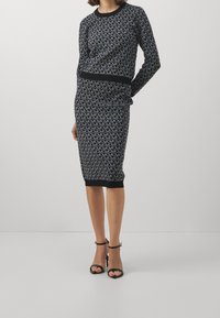 Abito a maglia nero e grigio con motivo, scollo rotondo e maniche lunghe, aderente al corpo, lunghezza fino al ginocchio, con orlo nero pieno.
