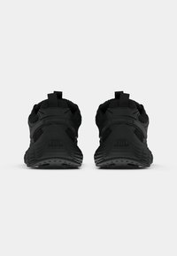 Pair of black athletic shoes shown from the back with textured soles and pull tabs against a plain light background.