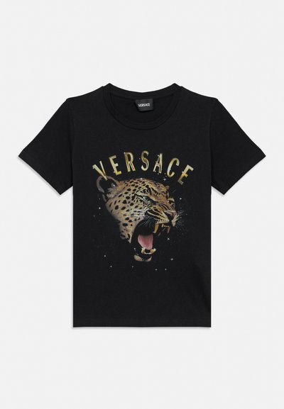 Tricou negru Versace cu un leopard înfuriat imprimat și textul "VERSACE" aurit arcuindu-se deasupra capului animalului.