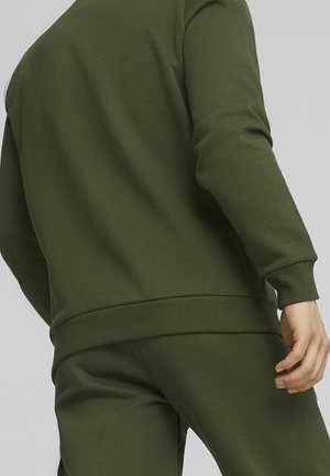 Sweatshirt vert olive avec une texture lisse, poignets et ourlet côtelés, doté d'une coupe décontractée et d'un col rond, accompagné d'un pantalon assorti.