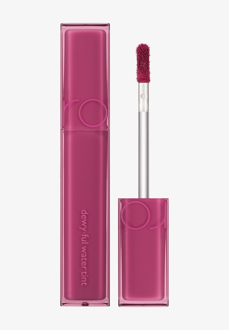 Rosa flytende leppetint i et gjennomsiktig rektangulært rør med en sølvfarget applikator. Merketekst "dewy.full water tint" er synlig.