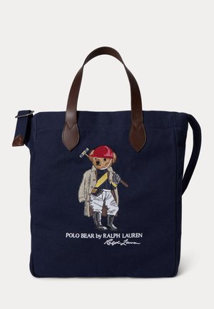 Borsa a tracolla navy con manici in pelle marrone, caratterizzata da un Polo Bear ricamato con abbigliamento da cavalcata che tiene un mazzuolo da polo, e logo Ralph Lauren.