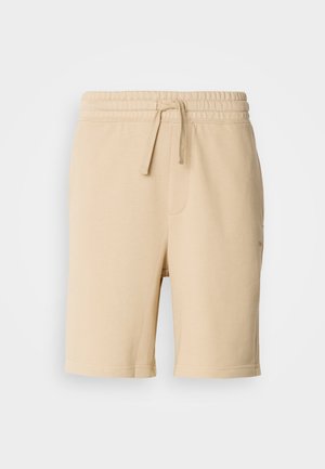 Beige cotton blend shorts with an elastic waistband, drawstring detail, side pocket, and straight leg cut. Smooth texture and simple design.