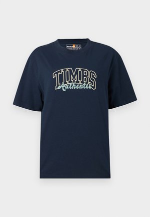 T-shirt en coton bleu marine avec une coupe décontractée. Il présente un design graphique avec "TIMBS Authentic" dans des couleurs contrastées. Manches courtes, col rond.