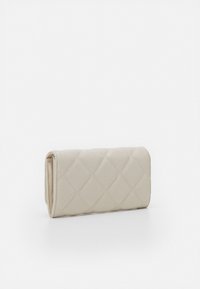 Cartera beige acolchada hecha de material sintético, con forma rectangular y costuras visibles en un patrón de diamante.