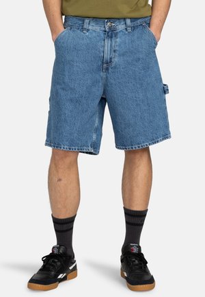 Pantalones cortos de mezclilla en azul claro con un corte holgado, que cuentan con bolsillos laterales y un ligero desgaste. El material tiene un aspecto texturizado.