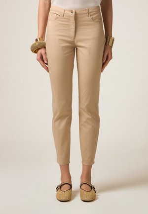 Beige slim-fit broeken met voorzakken, rits en een gladde textuur. Draag ze met geweven instappers die een minimalistisch ontwerp uitstralen.