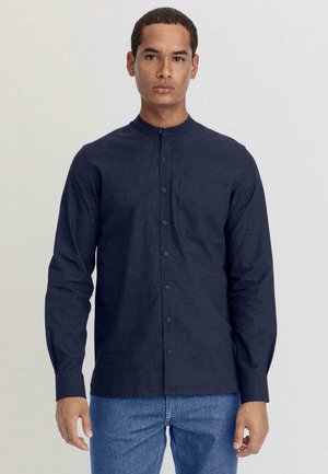 Marineblaues Langarmhemd mit Stehkragen, einer Brusttasche und Knopfleiste. Hergestellt aus strukturiertem Stoff und mit geradem Saum.