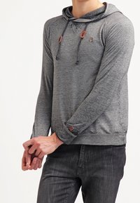 Felpa grigia a maniche lunghe con cappuccio e coulisse, caratterizzata da un tessuto testurizzato, piccolo logo sul petto e dettagli a contrasto sui polsini.