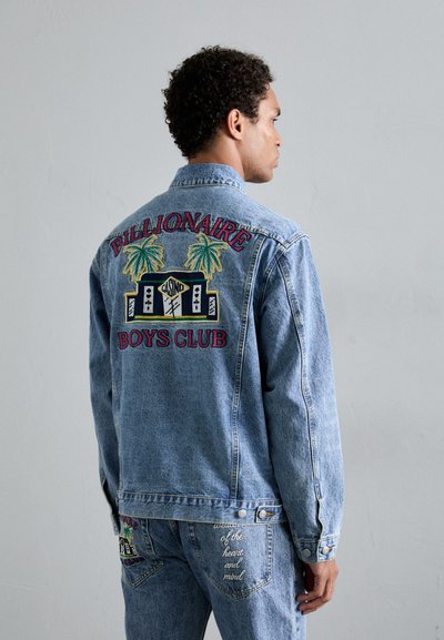 Lichtblauwe denimjas met geborduurde afbeeldingen op de achterkant, waaronder palmbomen en tekst. De jas heeft een recht, casual model.
