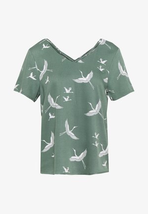 Haut vert à manches courtes avec des motifs d'oiseaux grue blancs et un col en V.