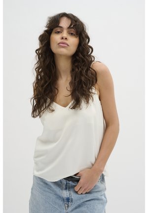 Cream, sleeveless satin top with a V-neckline. Smooth texture, loose fit, and drapes softly. Paired with light blue denim bottoms.