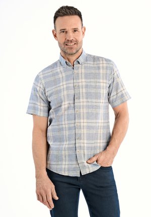 Camisa de botones de manga corta en un patrón de cuadros azul claro y crema, con un bolsillo en el pecho y un ajuste relajado. La tela tiene una textura suave.