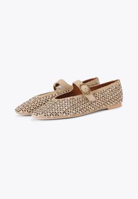 Ballerine in suede beige decorate con borchie metalliche, design a punta e una fascia decorativa con fibbia circolare. Suola piatta, finitura testurizzata.