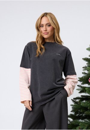 Mörkgrå oversized t-shirt med långärmar i rosa ränder. Har en rund halsringning och en subtil textdetalj på bröstet. Mjuk tygstruktur.