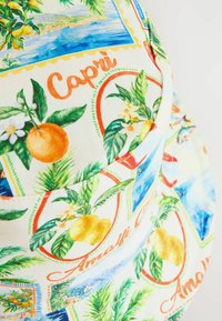 Chapeau seau avec un imprimé vibrant de citrons, d'oranges et de plantes tropicales sur un fond clair. Fabriqué en tissu, forme structurée.