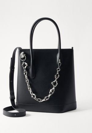 Black leather tote bag with a structured design, featuring a silver chain accent and dual handles. Includes a detachable leather strap.