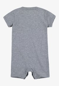 Γκρι βαμβακερό ολόσωμο σορτς με κοντά μανίκια, στρογγυλή λαιμόκοψη και κουμπώματα με clips στο κάτω μέρος. Μαλακή, λεία υφή και casual σχεδίαση.