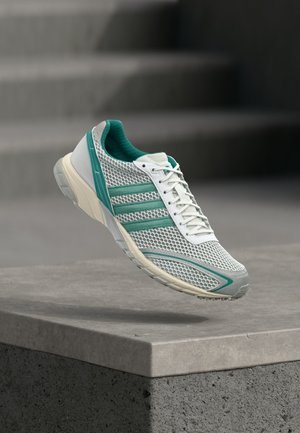 Lengvas, kvėpuojantis sportbačiai balta ir turkio spalvomis. Yra tinklinis viršus, trys turkio spalvos dryžiai, paminkštinta liežuvis ir tekstūruota guminė pado dalis.