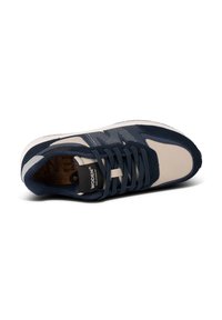 Navy and beige athletic shoe with mesh upper, suede accents, and textured sole. Features laces and logo on tongue.