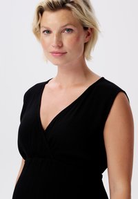 Schwarzes Kleid mit V-Ausschnitt und kurzen Ärmeln, aus strukturiertem Stoff mit subtilen Falten, entworfen für eine figurbetonte Silhouette.