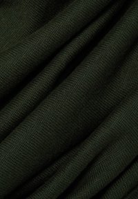 Donkergroen gebreide stof met opgevouwen rimpels die een gedetailleerde textuur en zachte wollen vezels laten zien.