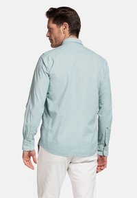 Lichtblauw button-up shirt met lange mouwen, gemaakt van ademend materiaal; heeft een standaard kraag en knoopmanchetten.